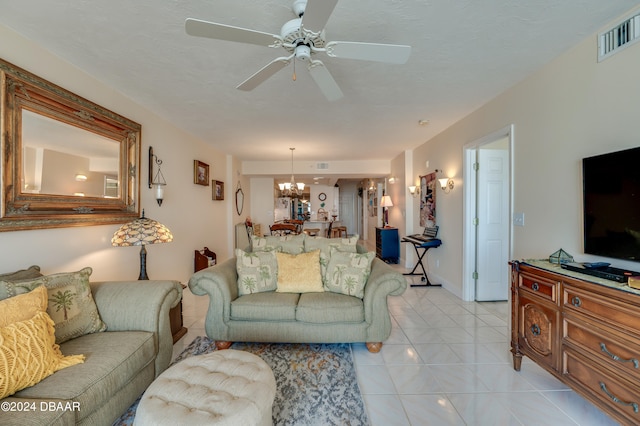 living room with ceiling fan with notable chandelier and light tile patterned floors