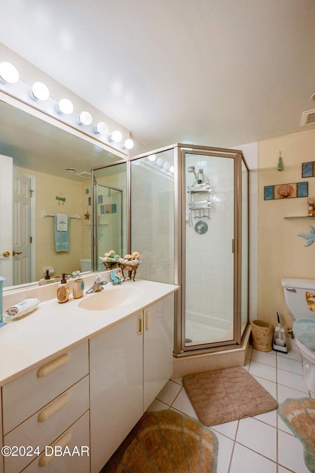 bathroom featuring walk in shower, tile patterned flooring, vanity, and toilet