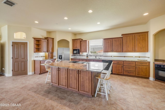 4690 S Atlantic Ave, Ponce Inlet, FL 32127 - kitchen with black appliances, arched walkways, open shelves, brown cabinets, and recessed lighting