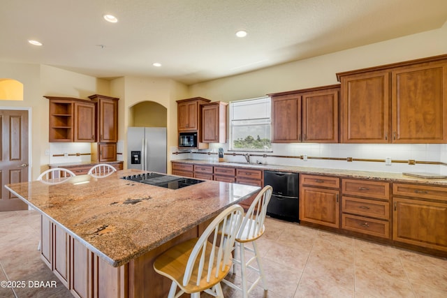 4690 S Atlantic Ave, Ponce Inlet, FL 32127 - kitchen with black appliances, arched walkways, open shelves, brown cabinets, and a kitchen bar