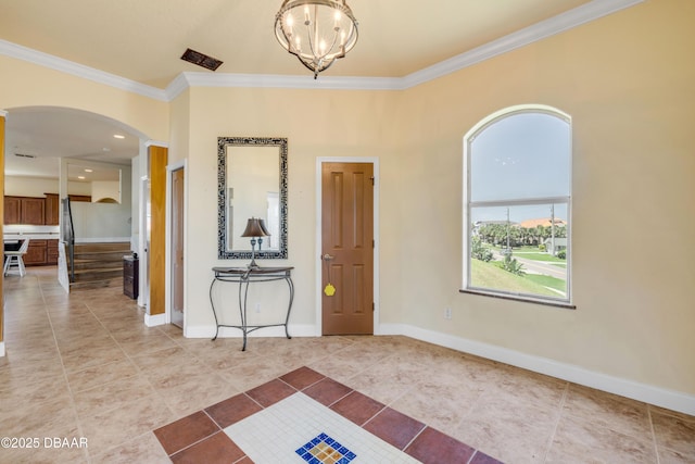 4690 S Atlantic Ave, Ponce Inlet, FL 32127 - entryway with ornamental molding, arched walkways, a chandelier, and light tile patterned floors