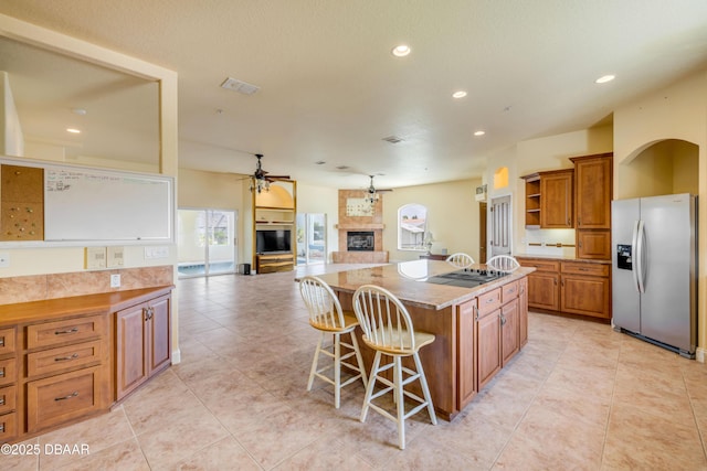 4690 S Atlantic Ave, Ponce Inlet, FL 32127 - kitchen featuring stainless steel fridge with ice dispenser, ceiling fan, plenty of natural light, brown cabinetry, and recessed lighting