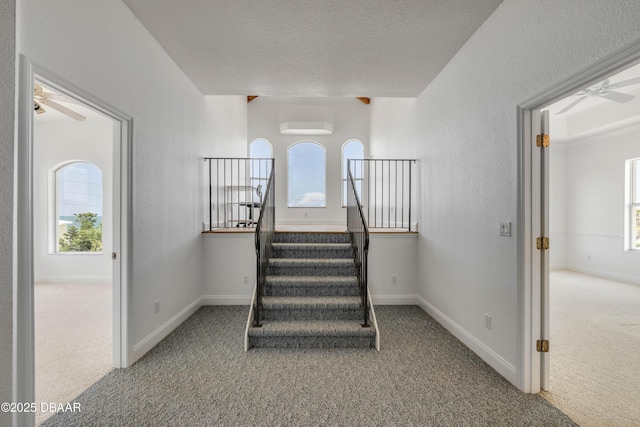 4690 S Atlantic Ave, Ponce Inlet, FL 32127 - stairs with a ceiling fan, carpet flooring, a wall unit AC, and a textured ceiling