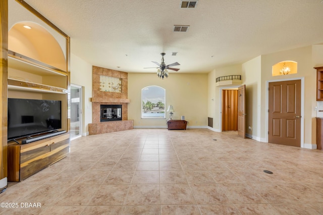 4690 S Atlantic Ave, Ponce Inlet, FL 32127 - unfurnished living room featuring ceiling fan, a fireplace, light tile patterned flooring, and a textured ceiling