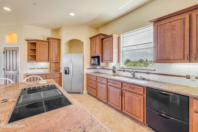 4690 S Atlantic Ave, Ponce Inlet, FL 32127 - kitchen with black appliances, open shelves, decorative backsplash, brown cabinets, and arched walkways