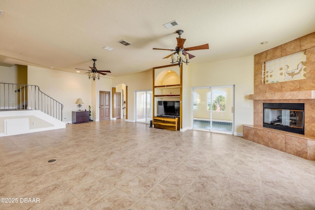 4690 S Atlantic Ave, Ponce Inlet, FL 32127 - unfurnished living room with a ceiling fan, tile patterned flooring, a fireplace, stairs, and arched walkways