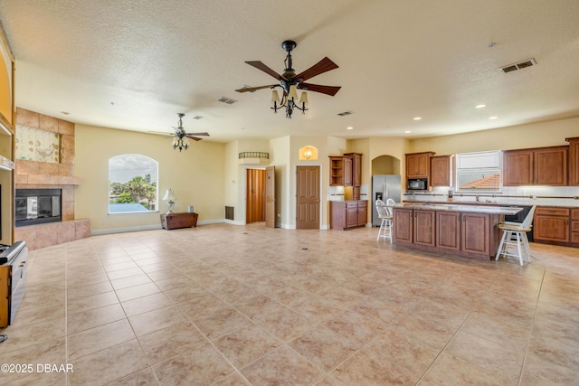 4690 S Atlantic Ave, Ponce Inlet, FL 32127 - kitchen featuring stainless steel refrigerator with ice dispenser, open floor plan, ceiling fan, plenty of natural light, and recessed lighting