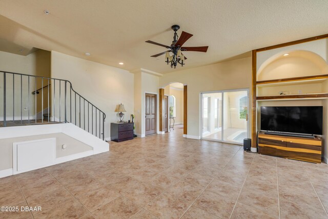 4690 S Atlantic Ave, Ponce Inlet, FL 32127 - unfurnished living room with arched walkways, ceiling fan, recessed lighting, tile patterned floors, and stairway