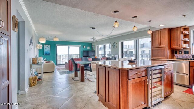 kitchen with wine cooler, crown molding, decorative light fixtures, a center island, and light stone countertops