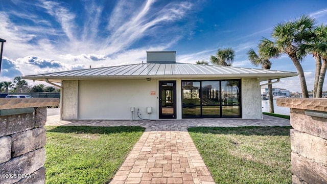 rear view of property with a water view and a yard