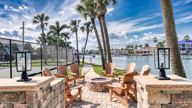 view of patio with a fire pit, an outdoor bar, and a water view