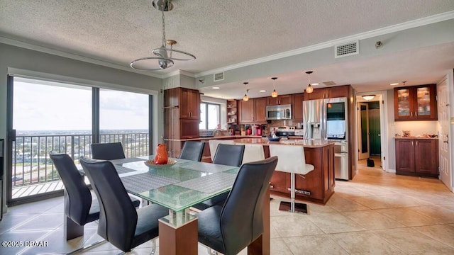 tiled dining area with crown molding and a textured ceiling