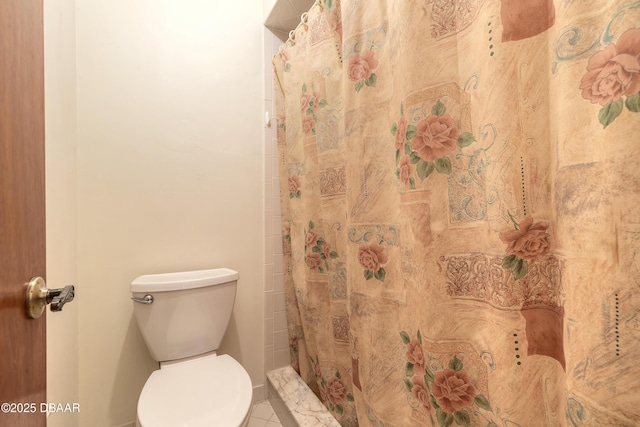 bathroom with curtained shower and toilet