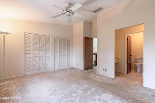 unfurnished bedroom with connected bathroom, high vaulted ceiling, and light carpet