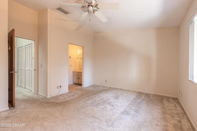 unfurnished bedroom featuring connected bathroom and light colored carpet