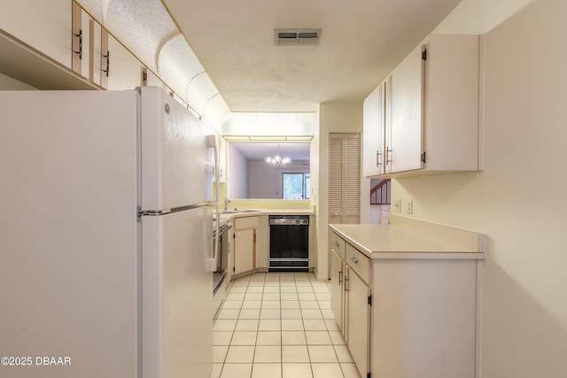 kitchen with light tile patterned floors, sink, black dishwasher, and white fridge