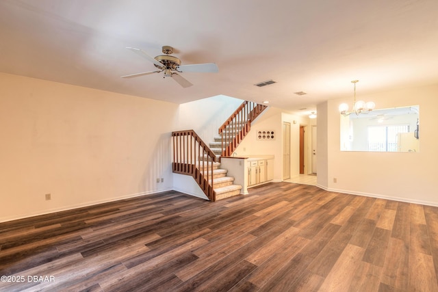 empty room featuring dark hardwood / wood-style flooring and ceiling fan with notable chandelier