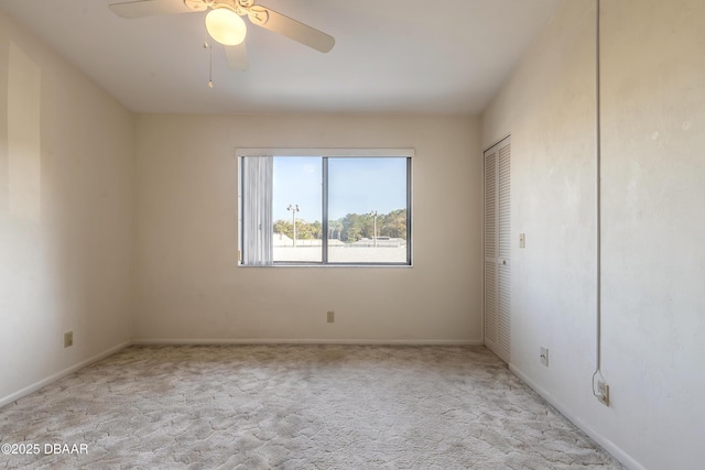 empty room with light colored carpet and ceiling fan