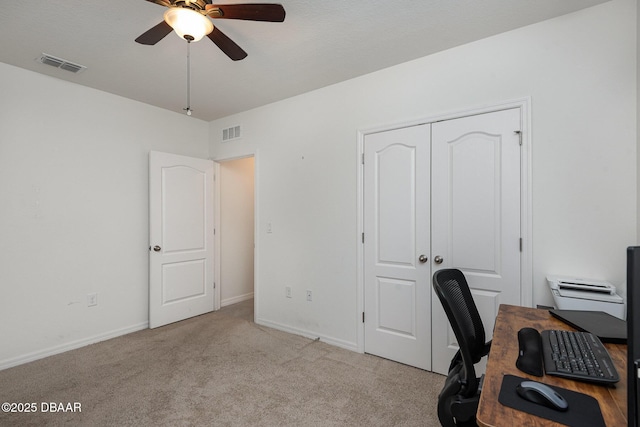 unfurnished office featuring light carpet and ceiling fan