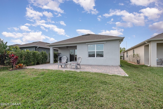 back of property with a lawn and a patio area