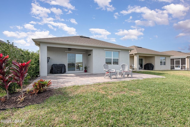 rear view of property with a patio, a yard, and ceiling fan