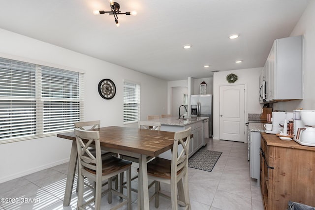 dining room featuring sink and light tile patterned floors