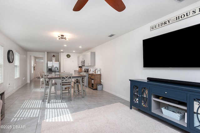 dining space with light tile patterned floors and ceiling fan