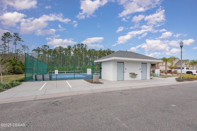 view of front of property with tennis court