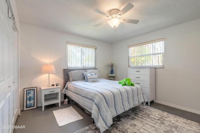 bedroom featuring multiple windows, baseboards, and a textured ceiling