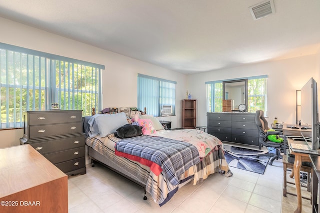 bedroom with light tile patterned floors, visible vents, and multiple windows