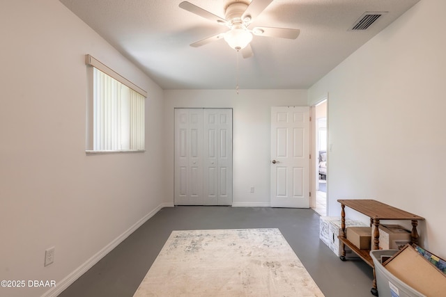 bedroom featuring baseboards, visible vents, ceiling fan, finished concrete floors, and a closet