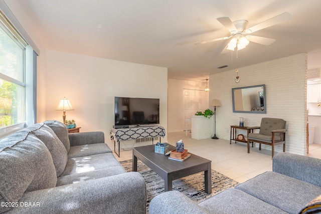 living room featuring light tile patterned floors, a ceiling fan, and visible vents