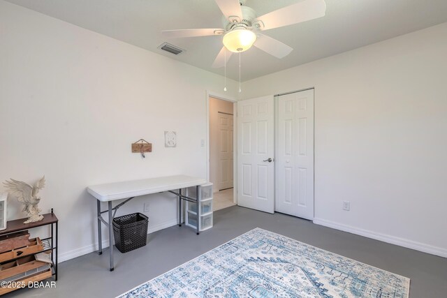 office space with a ceiling fan, finished concrete flooring, visible vents, and baseboards