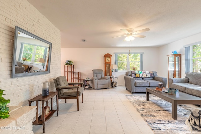 living room with light tile patterned floors, plenty of natural light, visible vents, and ceiling fan