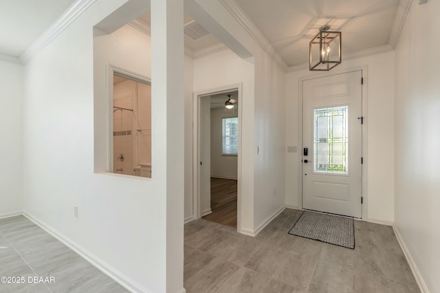 entrance foyer with plenty of natural light, baseboards, and ornamental molding