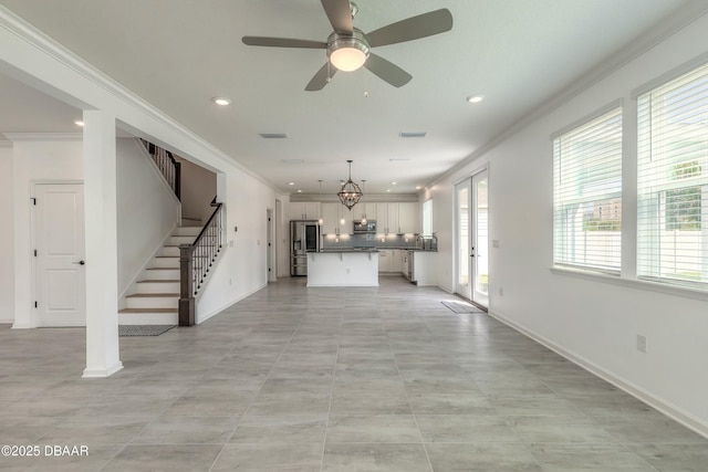 unfurnished living room featuring crown molding, recessed lighting, plenty of natural light, and stairs