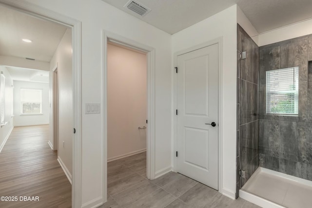 bathroom featuring visible vents, plenty of natural light, and a stall shower