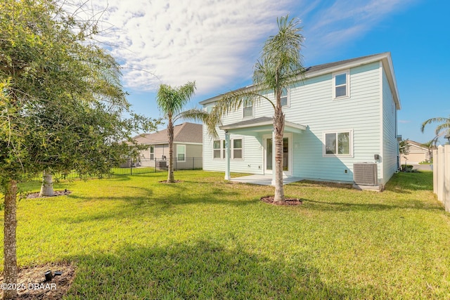 rear view of house with a lawn, fence, and a patio