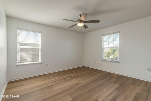 unfurnished room with baseboards, a ceiling fan, and wood finished floors