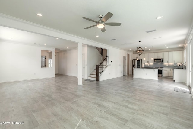 unfurnished living room with a sink, crown molding, and recessed lighting