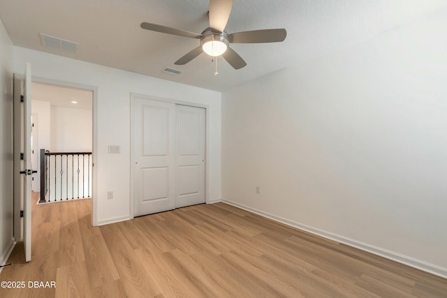 unfurnished bedroom with baseboards, light wood-style flooring, and visible vents