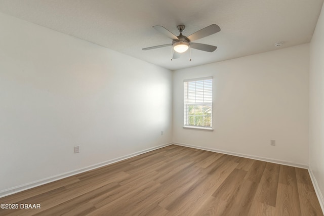 empty room with light wood-style floors, baseboards, and ceiling fan