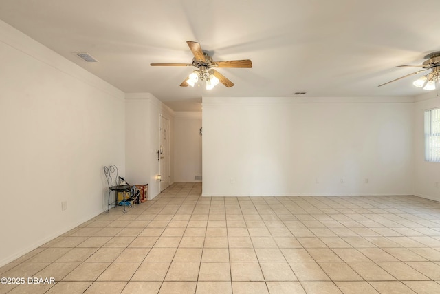 tiled empty room with ceiling fan and crown molding