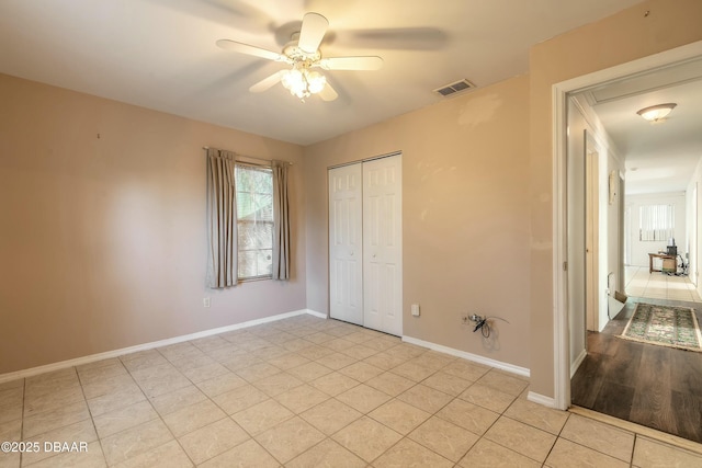 unfurnished bedroom featuring ceiling fan, light tile patterned flooring, and a closet