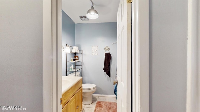 bathroom with tile patterned flooring, vanity, and toilet