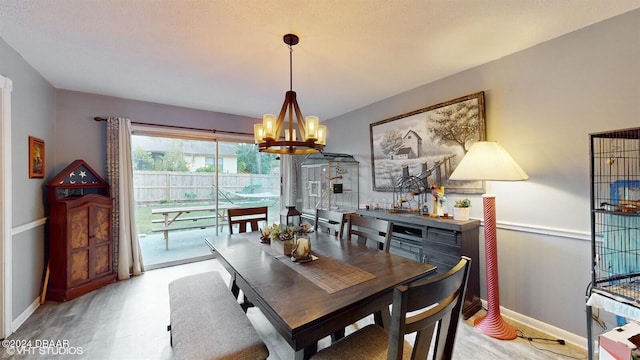 dining area with light hardwood / wood-style flooring and an inviting chandelier