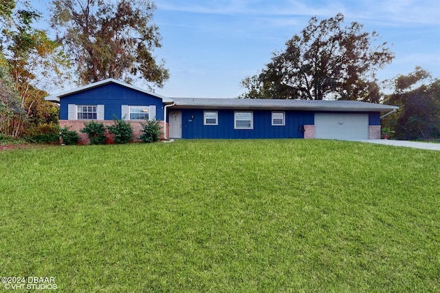 single story home featuring a front lawn and a garage