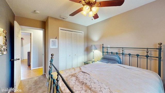 bedroom with a textured ceiling, a closet, ceiling fan, and light hardwood / wood-style floors