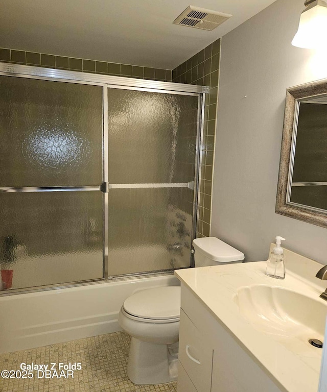 full bathroom with tile patterned flooring, vanity, toilet, and combined bath / shower with glass door