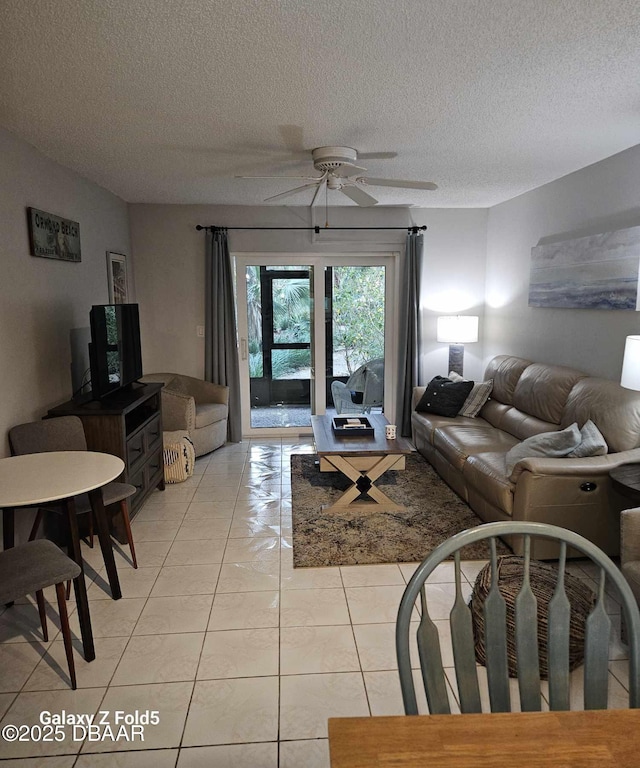 living room with light tile patterned floors, a textured ceiling, and ceiling fan